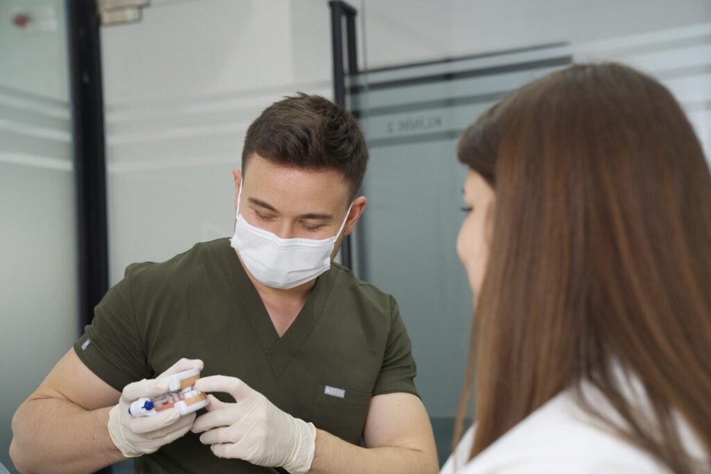 Dt. Onur Hökümdar hastasıyla diş tedavisi planlaması yaparken — Kemerburgaz diş kliniği