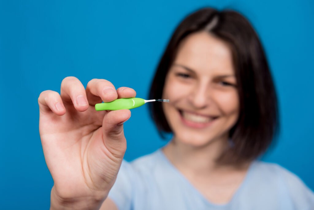 Ara yüz (interdental) fırçası kullanan kadın