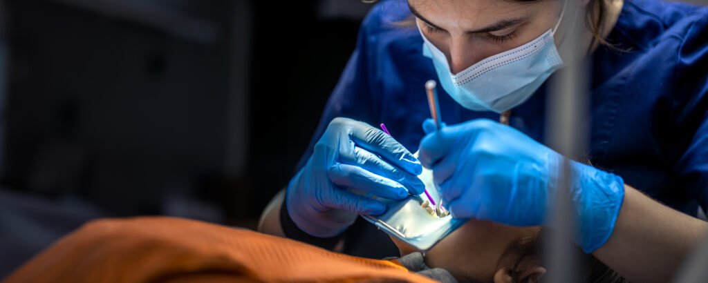 Diş hekimi çocuğun azı dişini tedavi ediyor — fissür örtücü uygulaması